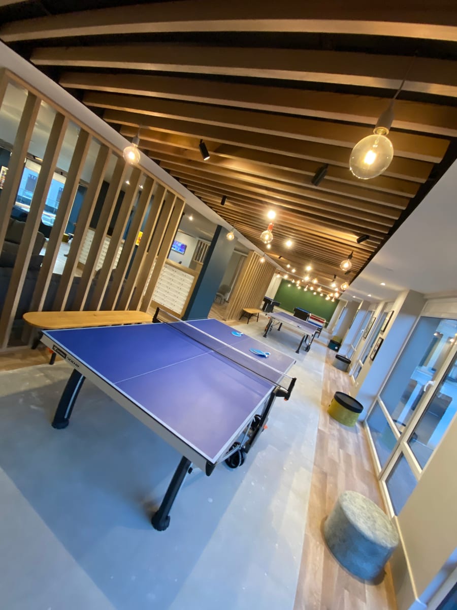 Games area with ping-pong tables and Edison-style pendant lights