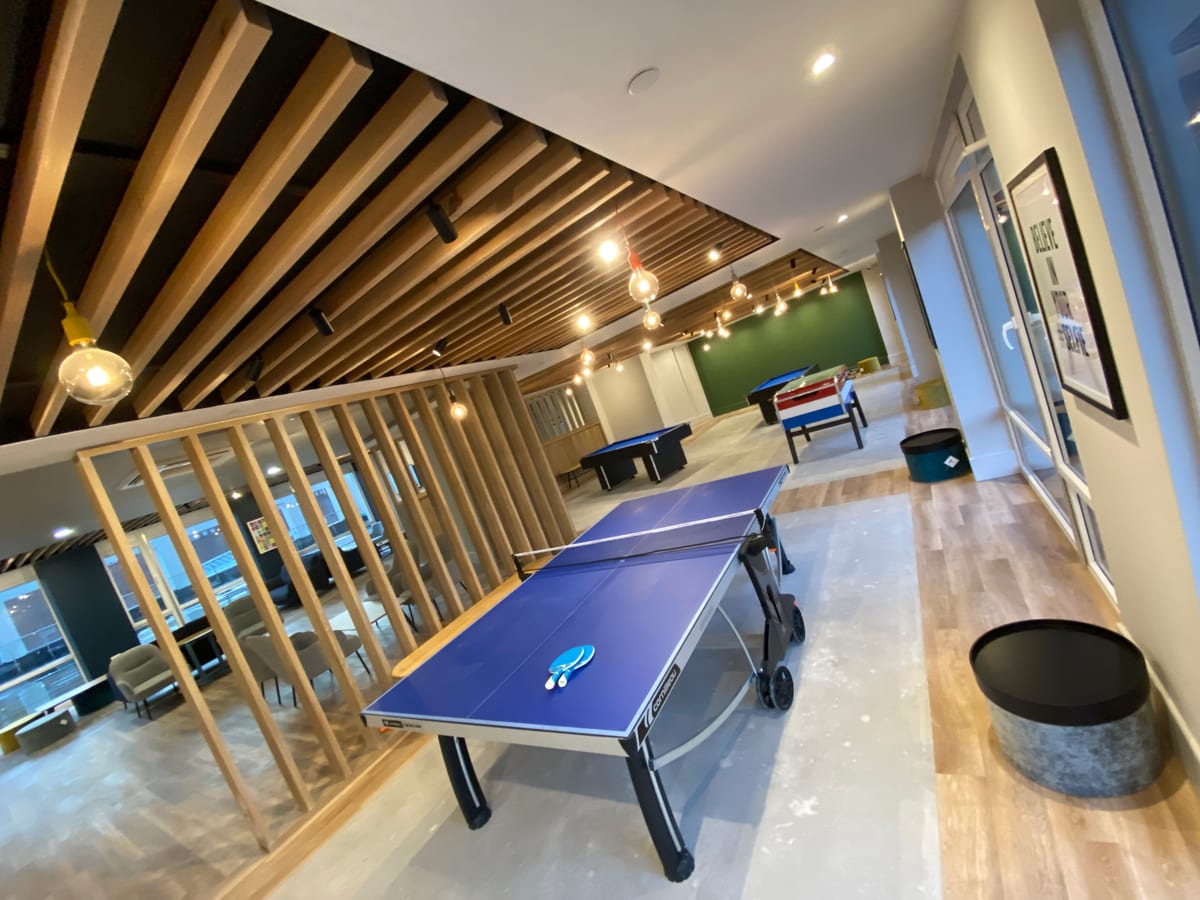 Games room with pool table, foosball, and feature pendant lighting