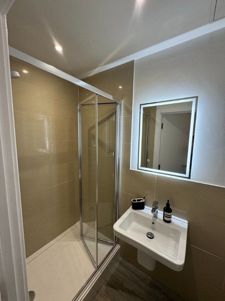 Ensuite bathroom with LED mirror and contemporary tiling