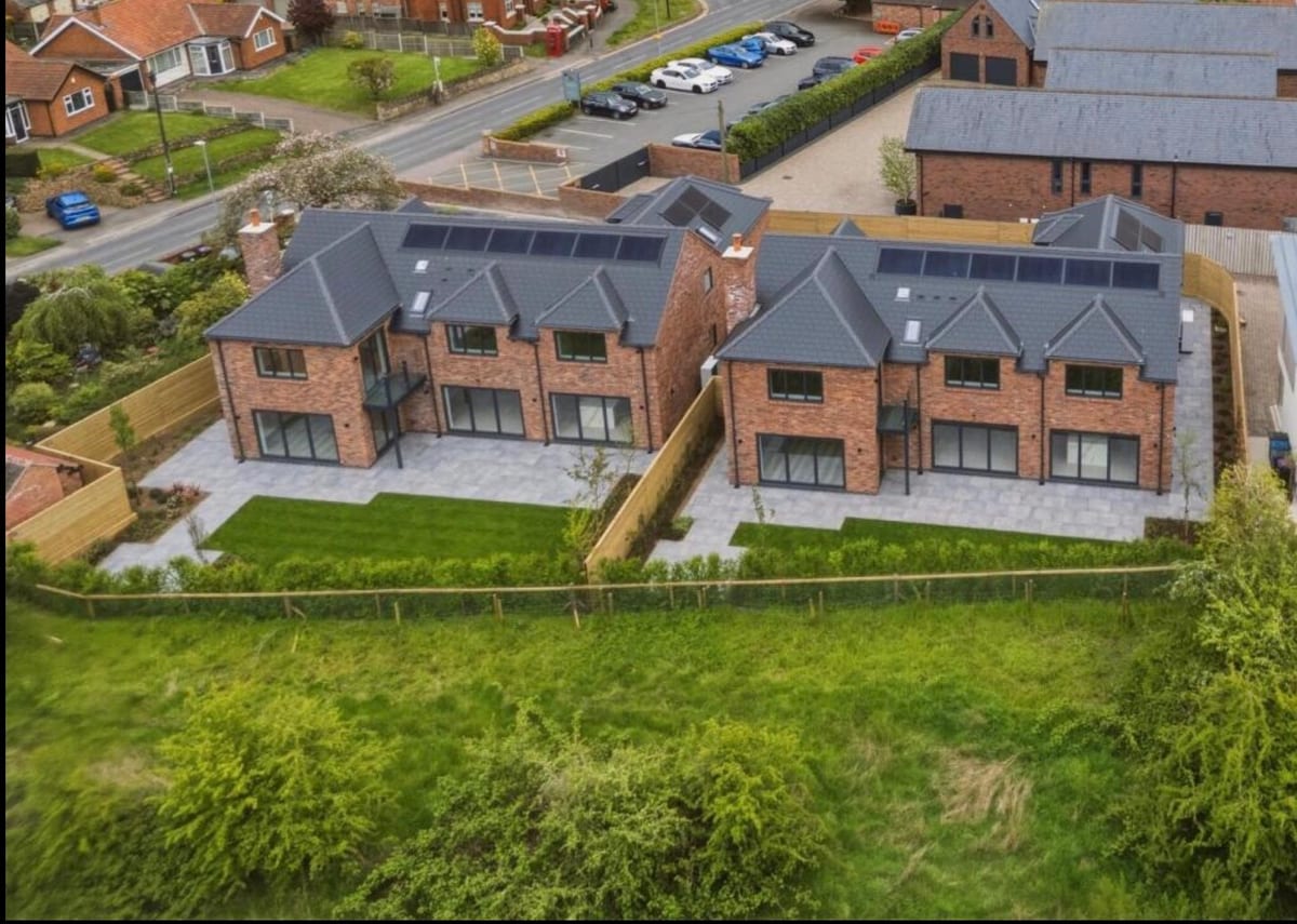 Aerial view of two luxury new-build homes at Plumtree with solar panels
