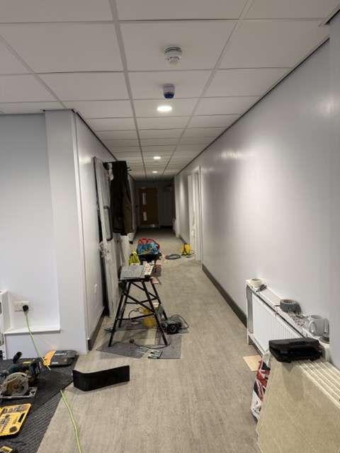 Finished corridor with wood flooring and recessed downlights