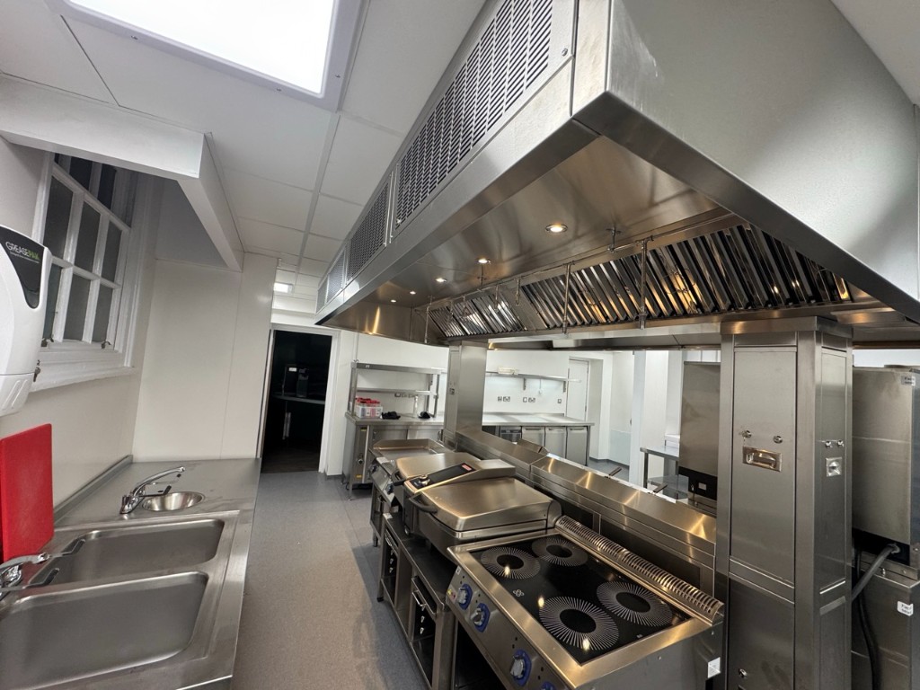 Production kitchen with induction hob and extractor lighting
