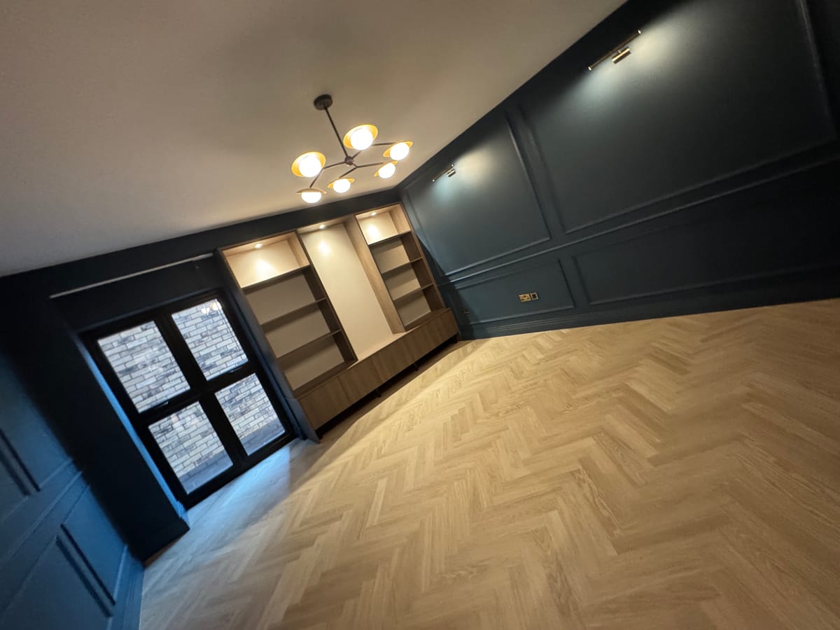 Living room with chandelier, picture lights, and built-in shelving