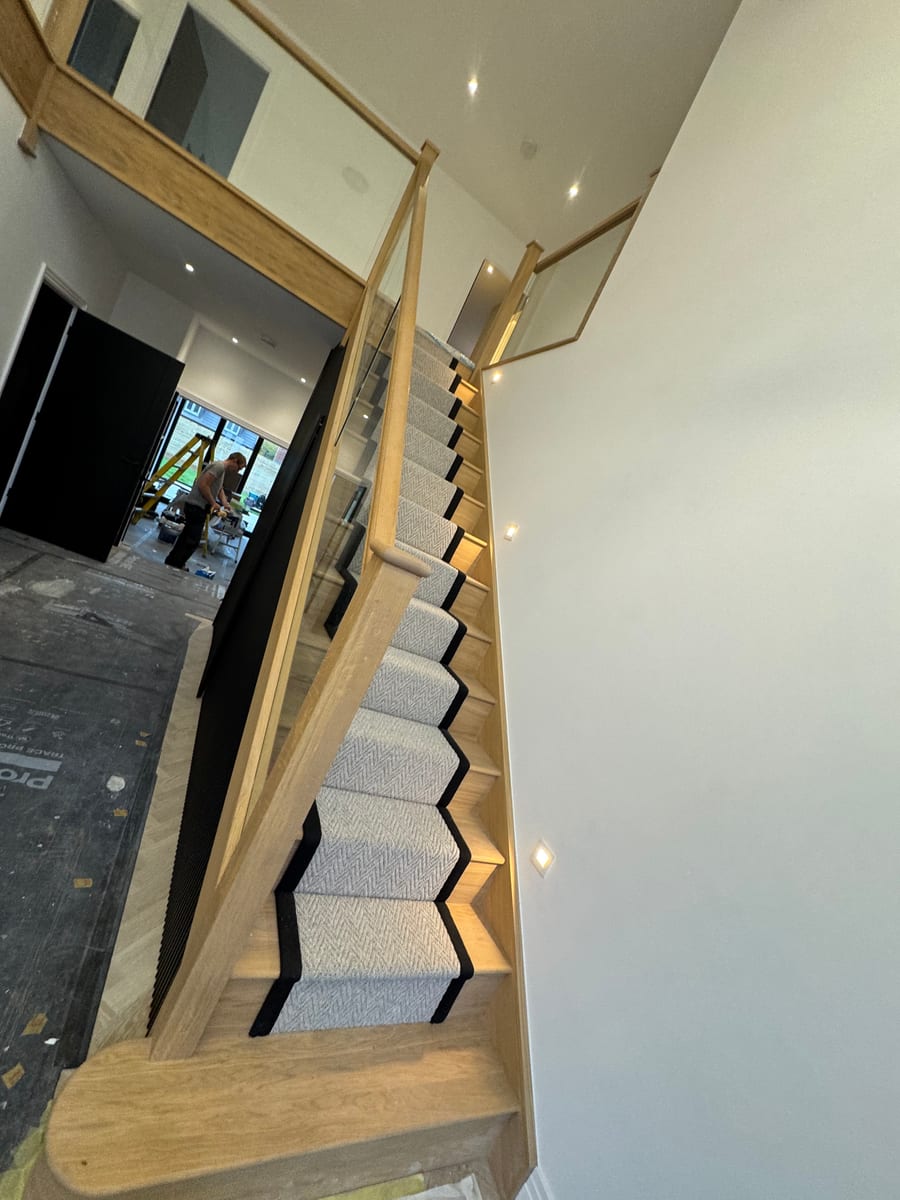 Staircase with glass balustrade and recessed step lighting